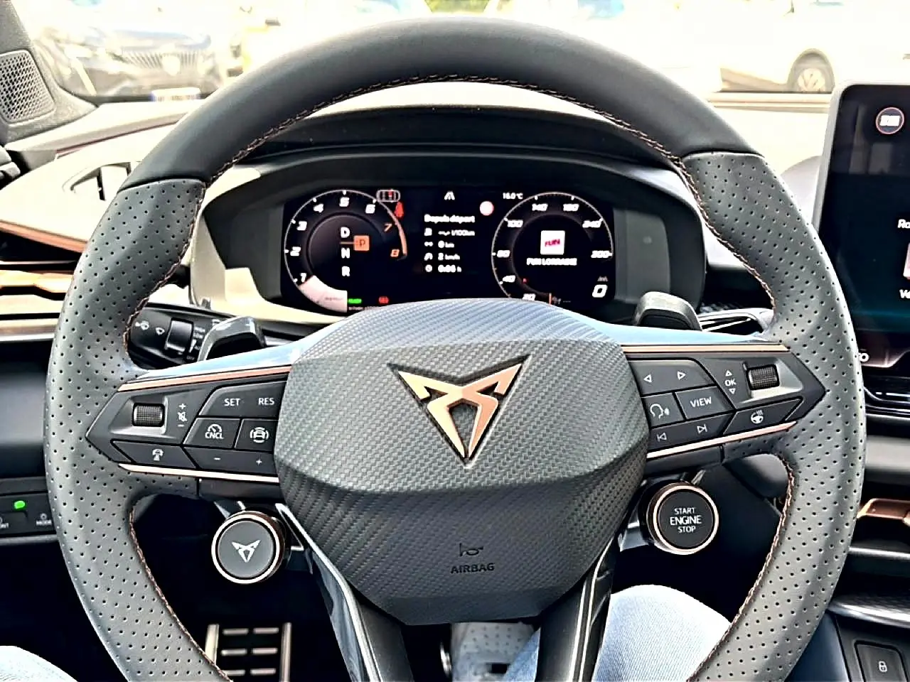 Vue rapprochée du volant cuir perforé gris et du tableau de bord digital d’une CUPRA TERRAMAR bleu fjord 2026.