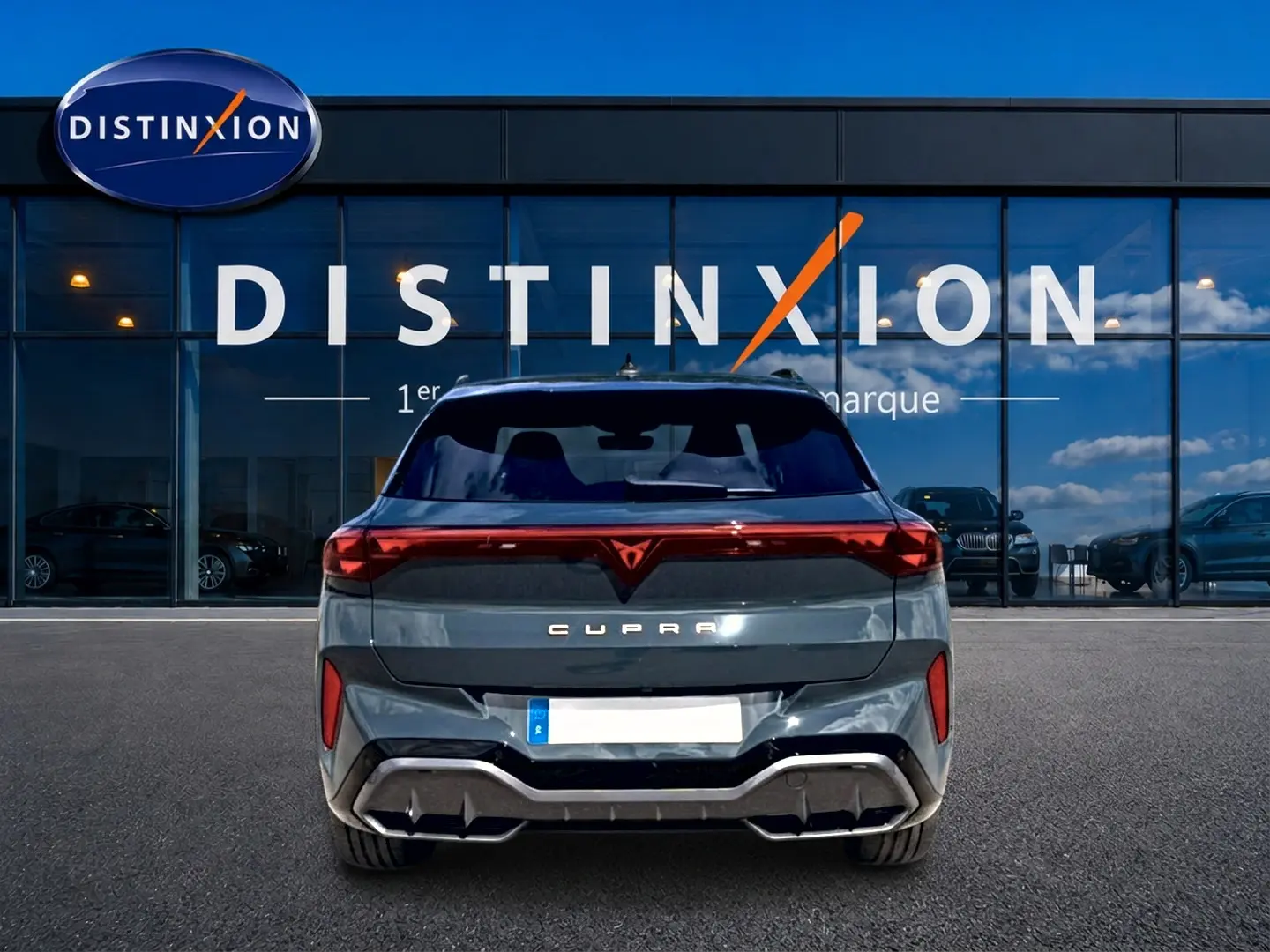 Vue arrière d'une CUPRA Terramar bleu fjord garée devant une vitrine avec logo Distinxion.