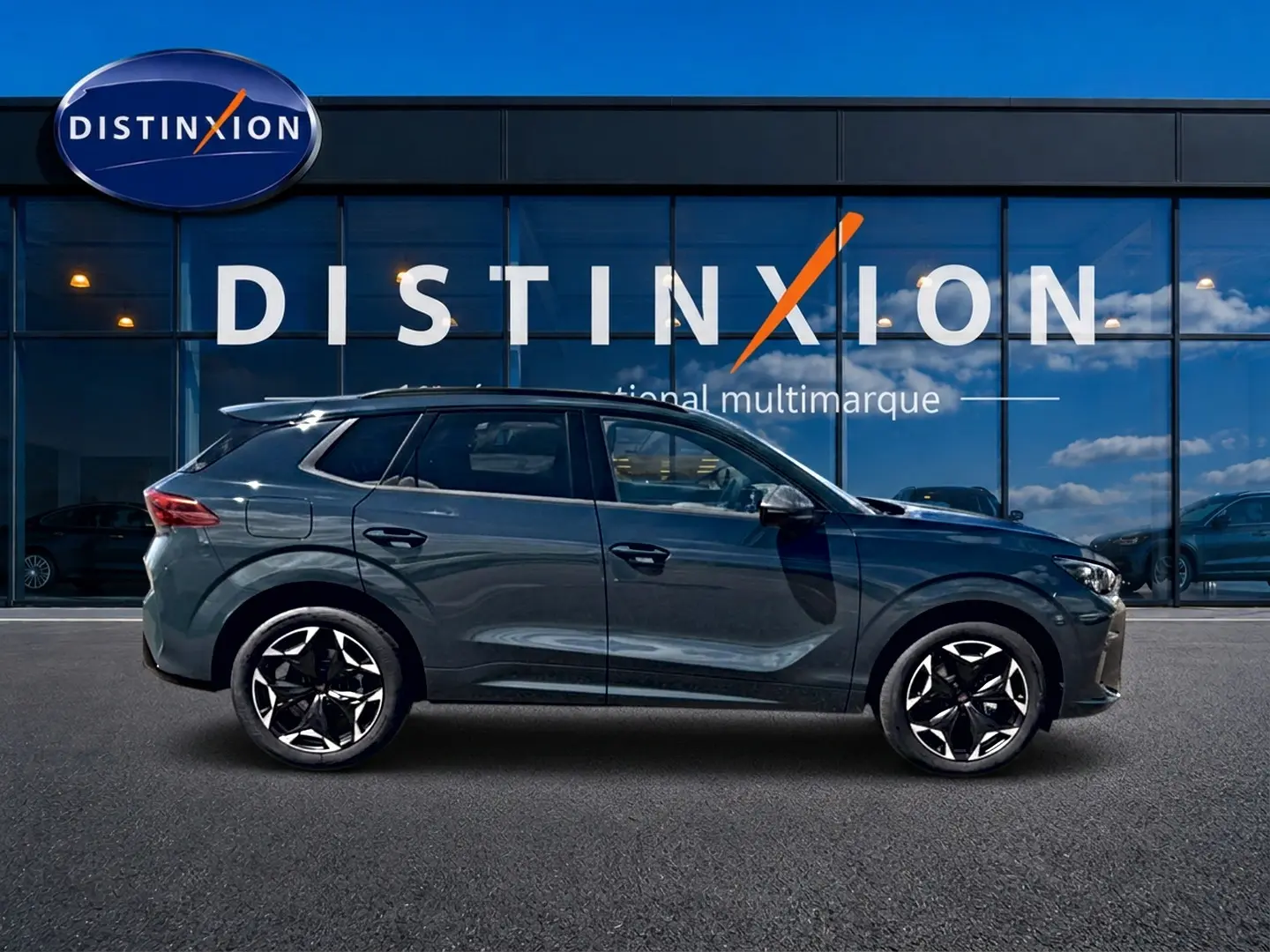 Vue latérale droite d'un CUPRA TERRAMAR 2026 bleu fjord avec jantes 19 pouces devant une vitrine Distinxion.