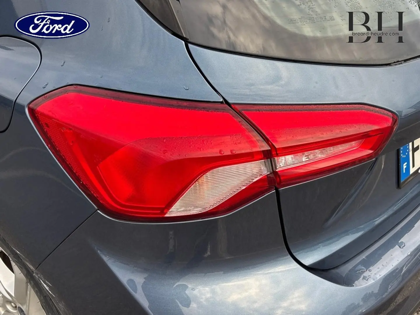 Gros plan sur le feu arrière droit d’une Ford Focus 2020 bleu azur métallisé, soulignant la teinte et les lignes du coffre.