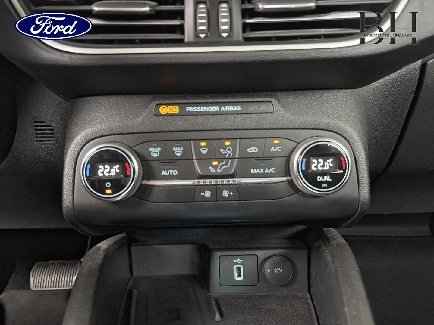 Gros plan sur la console centrale de la Ford Focus 2020, montrant la climatisation automatique et les ports USB et 12V.