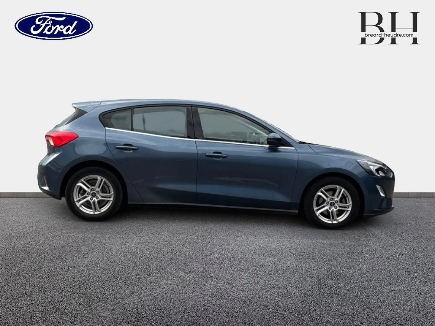 Vue de profil côté gauche d'une Ford Focus 1.5 EcoBlue bleu azur métallisé avec jantes alliage et poignées ton carrosserie.