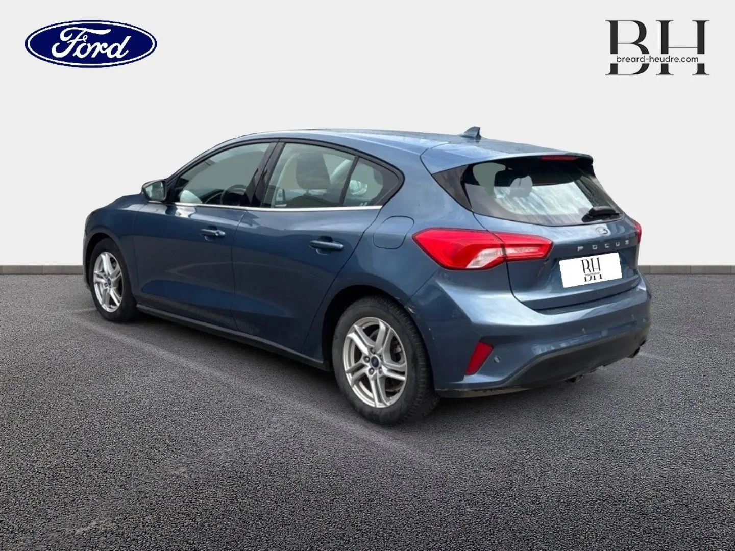 Ford Focus 1.5 EcoBlue bleu azur métallisé vue 3/4 arrière côté gauche, jantes alu et feux arrière LED visibles.
