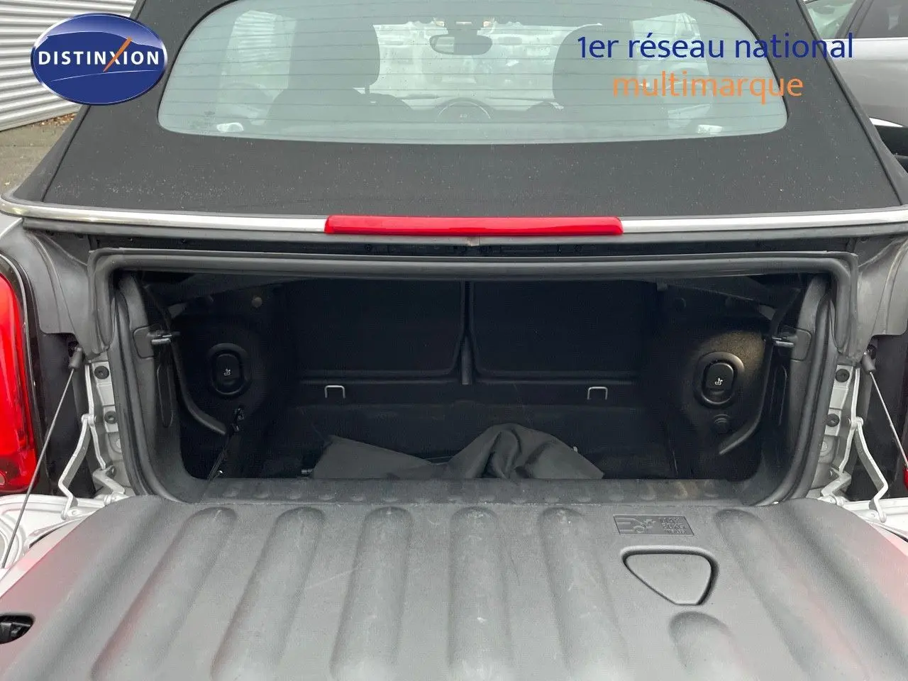 Coffre ouvert d'une MINI Cabriolet F57 Melting Silver, vue arrière mettant en valeur l'espace de rangement noir.