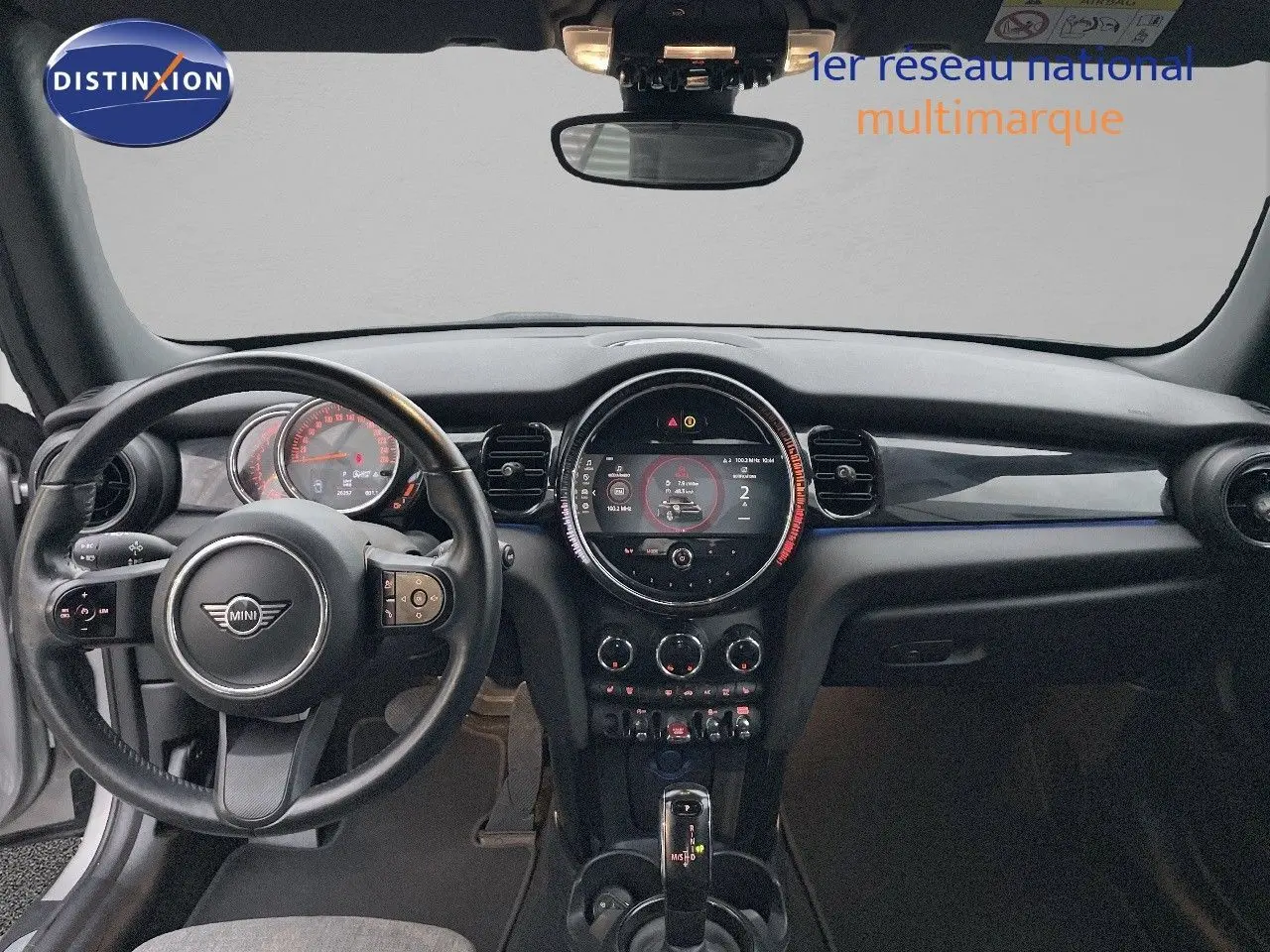 Vue frontale de l'habitacle du MINI Cabriolet Melting Silver, avec tableau de bord et volant noir visible.
