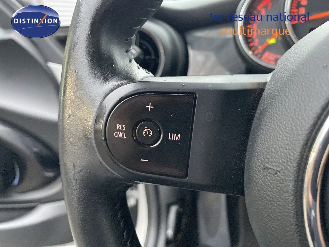 Gros plan sur les commandes de régulateur de vitesse au volant d'une MINI Cabriolet 2023 couleur Melting Silver Metal.