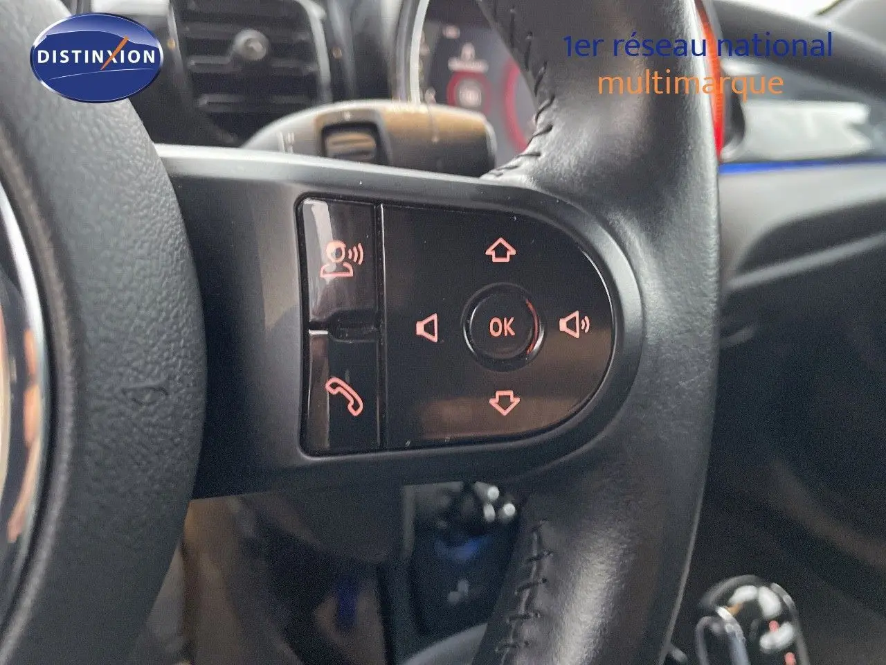 Gros plan sur les commandes au volant en cuir noir de la MINI Cabriolet Melting Silver 2023, avec boutons rétroéclairés.