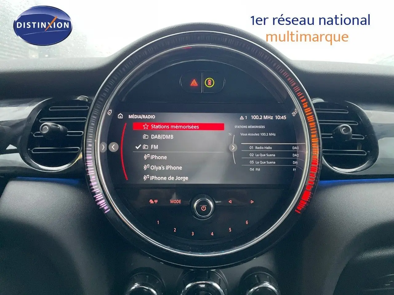 Vue rapprochée du tableau de bord du MINI Cabriolet 2023 avec écran central rond affichant les stations radio.