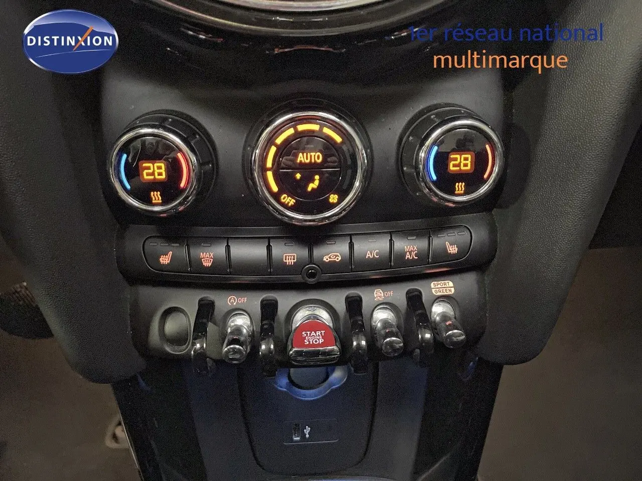 Gros plan sur la console centrale noire du MINI Cabriolet 2023 avec commandes clim et bouton start/stop rouge.