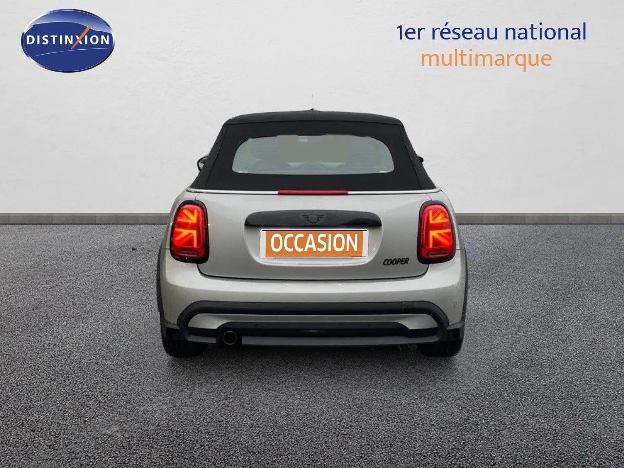 Vue arrière d'une MINI Cabriolet Melting Silver 2023 avec toit noir et feux arrière LED allumés.