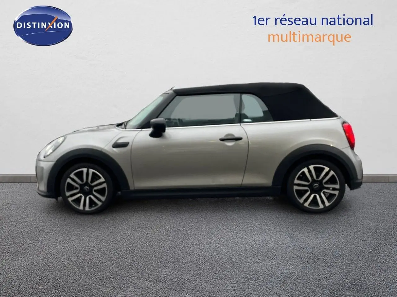 Profil gauche d'une MINI Cabriolet 2023 couleur Melting Silver avec capote noire fermée sur fond neutre.