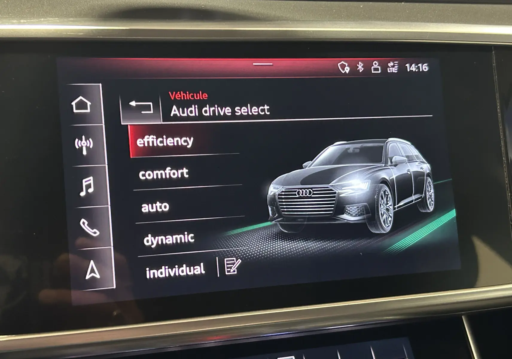 Affichage intérieur du système Audi Drive Select montrant une Audi A6 Avant noire en 3/4 avant droit sur l'écran tactile.