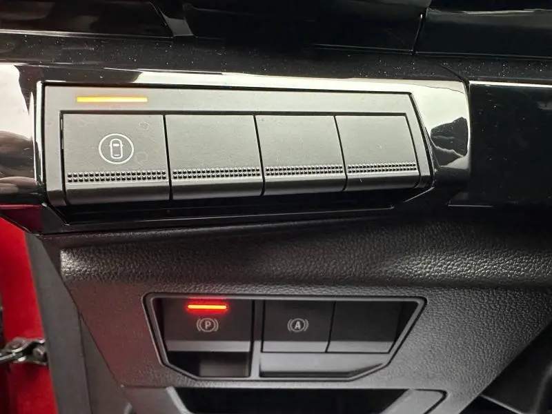 Détail des commandes intérieures avec bouton de verrouillage et frein à main électronique allumé sur Renault Austral rouge flamme 2025.