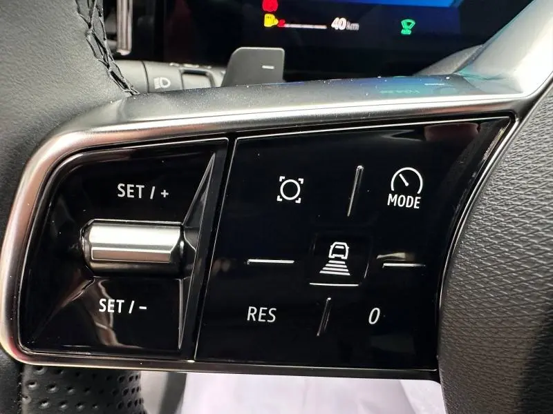 Gros plan sur les commandes au volant du Renault Austral 2025, boutons noirs avec fonctions de régulateur et mode de conduite.