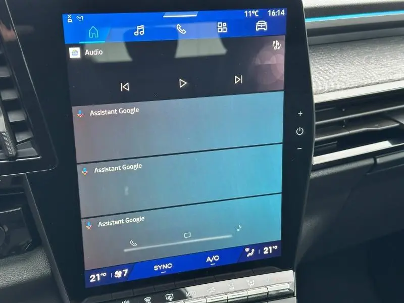 Écran tactile central du tableau de bord du Renault Austral 2025, affichant l'interface audio et Google Assistant.