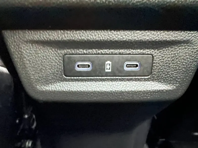 Gros plan sur deux ports USB-C de recharge situés à l'arrière d'un Renault Austral 2025 Rouge Flamme hybride.