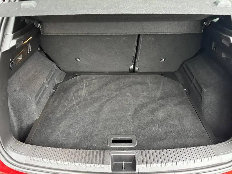 Coffre ouvert vu de l'arrière d'un Renault Austral 2025 Rouge Flamme, montrant un espace de chargement propre et spacieux.