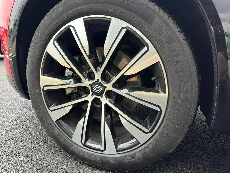 Gros plan sur la jante alliage bicolore du Renault Austral Rouge Flamme 2025, avec pneu Michelin visible.