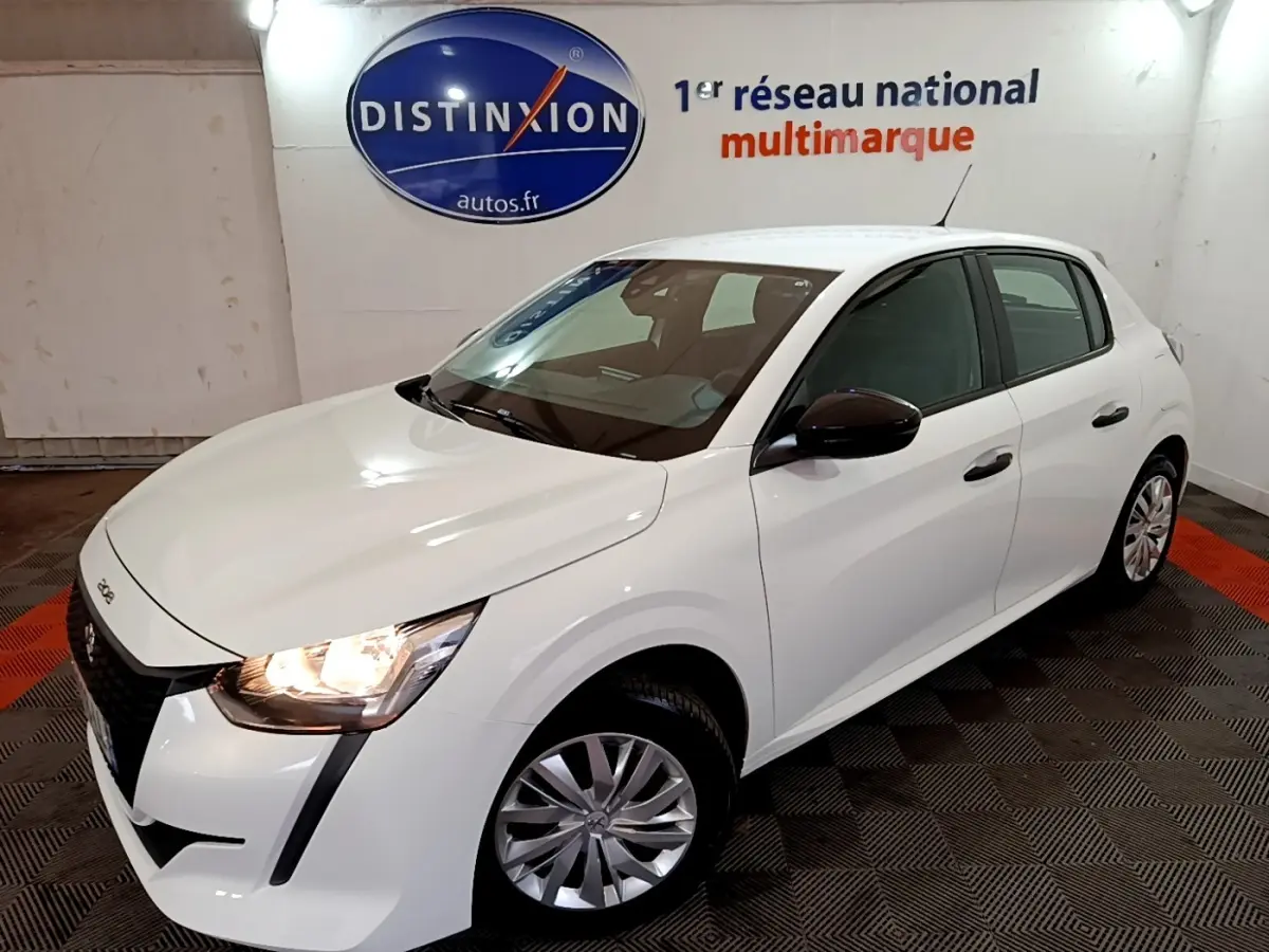 Peugeot 208 blanche vue en 3/4 avant droit, phare avant allumé et rétroviseur noir contrastant.