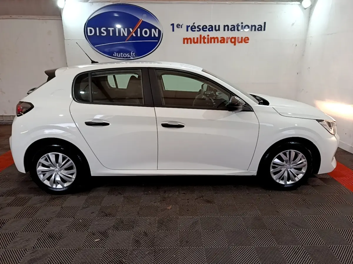 Vue latérale droite d'une Peugeot 208 blanche de 2022, compacte et élégante, en intérieur showroom.