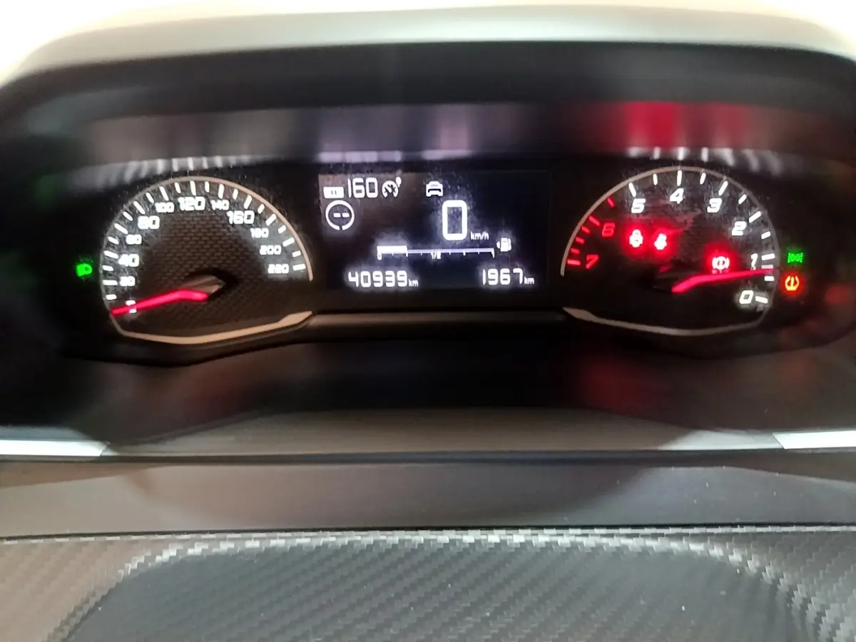 Tableau de bord numérique de la Peugeot 208 Diesel 2022, affichage vitesse et compte-tours en gros plan.