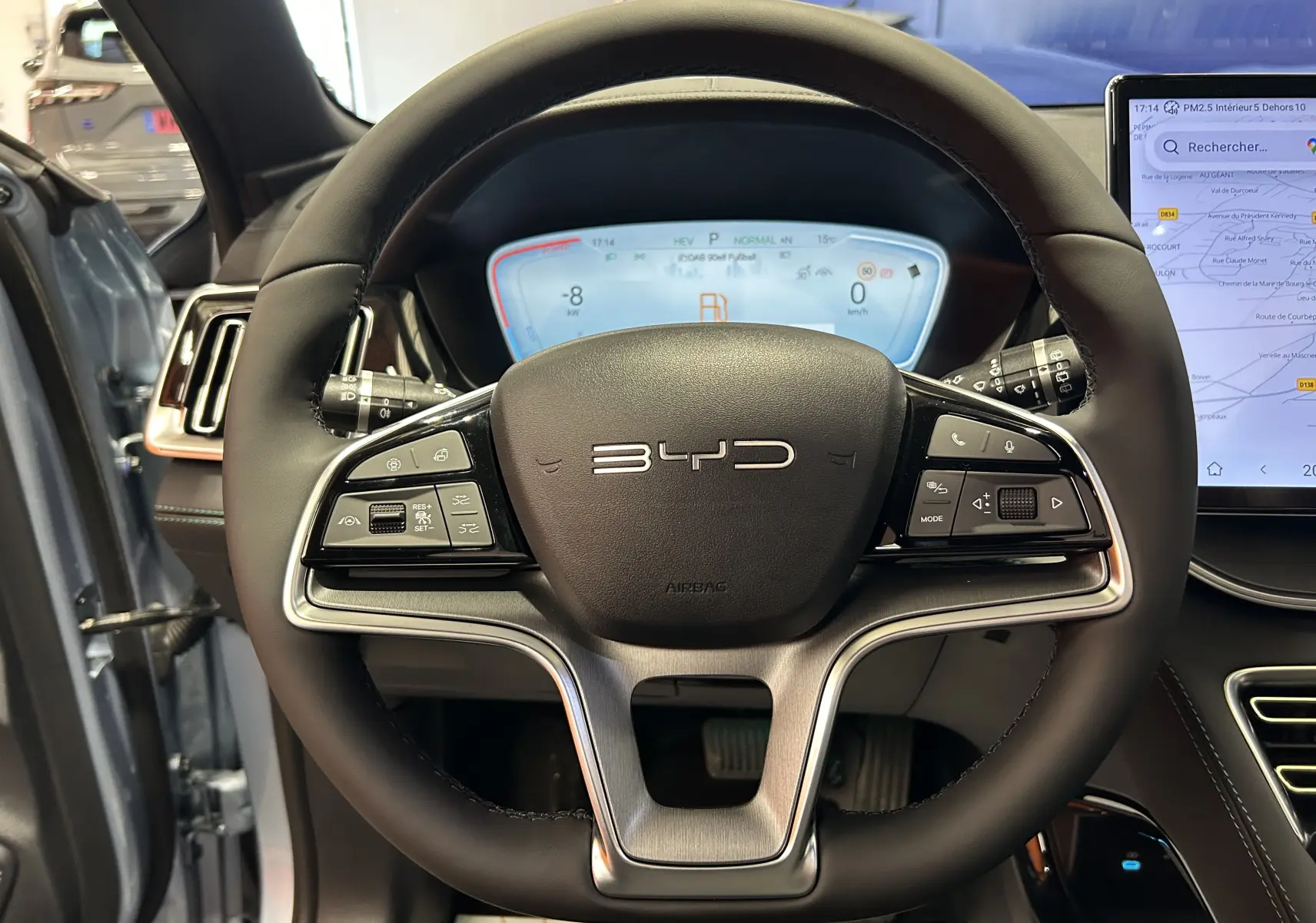 Vue rapprochée du volant noir du BYD SEAL U 2025 avec tableau de bord numérique et écran tactile latéral.