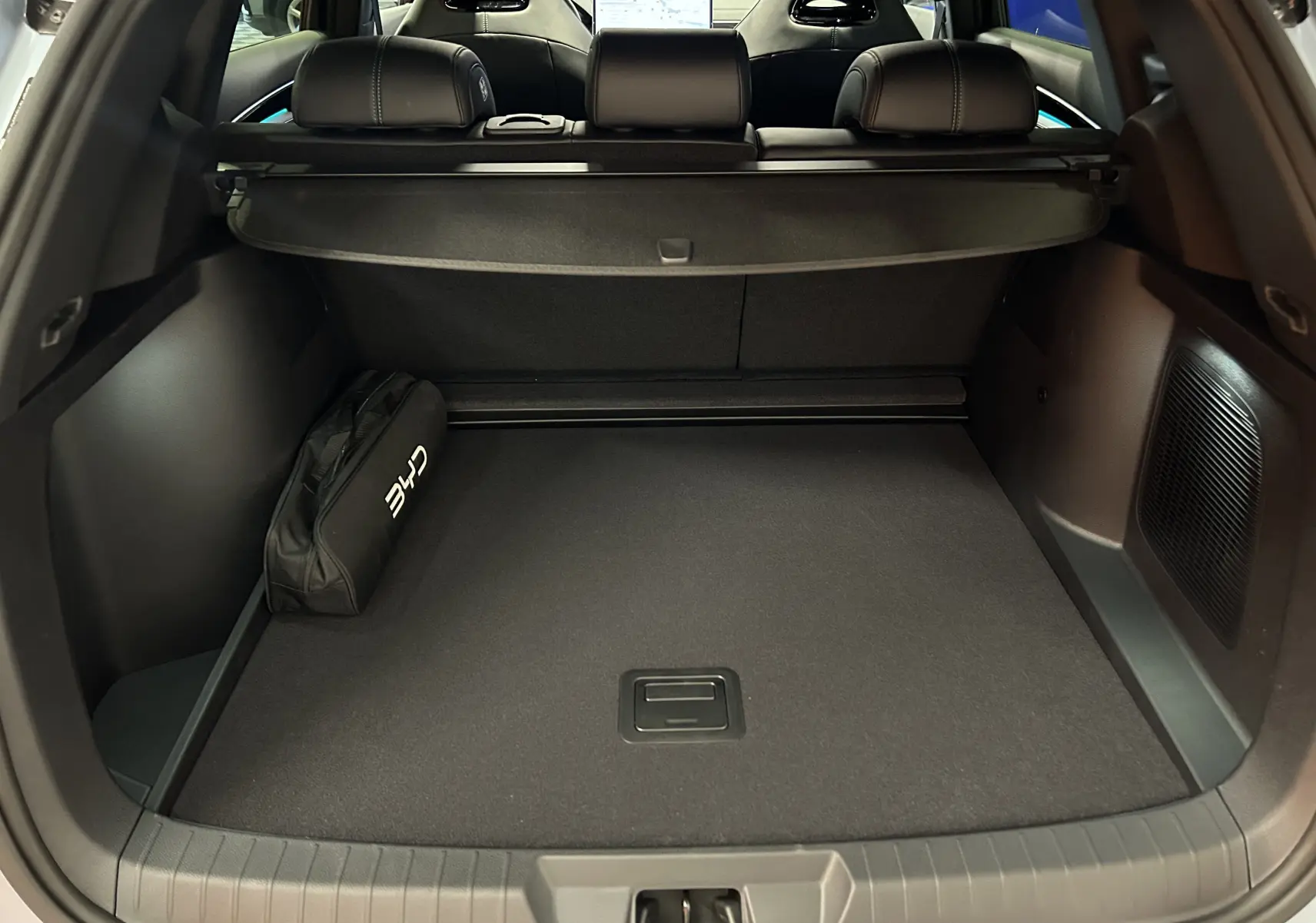 Vue du coffre ouvert du BYD SEAL U 2025 en TIAN QING METAL, avec cache-bagages et sac de rangement noir.