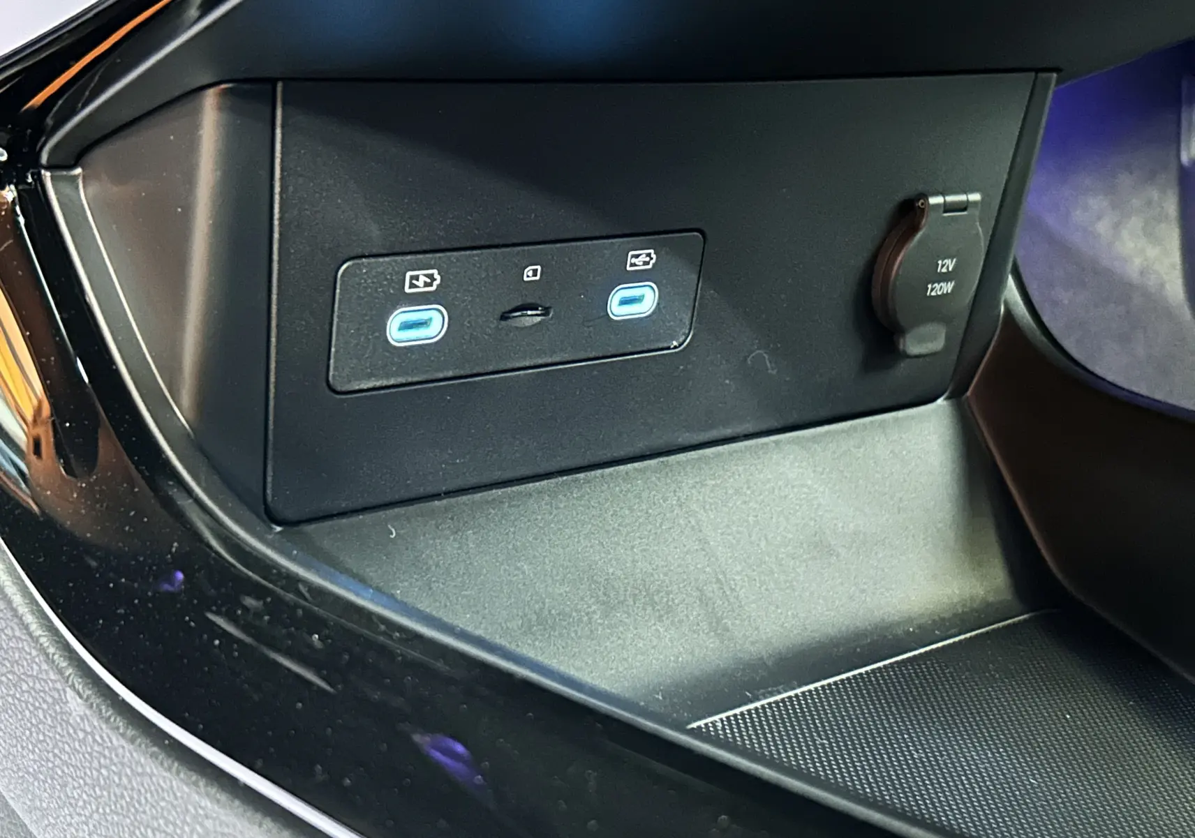 Gros plan sur la console centrale du BYD SEAL U avec deux ports USB-C éclairés en bleu et une prise 12V.