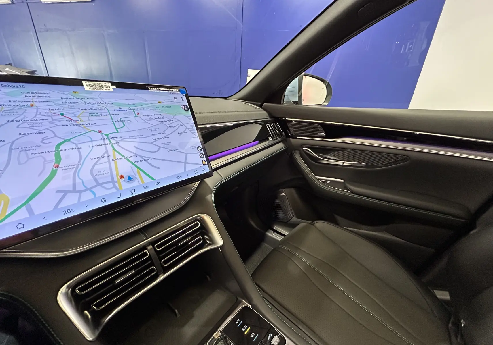 Vue intérieure côté passager du BYD SEAL U 2025, avec écran tactile GPS, éclairage d'ambiance violet et sellerie cuir noir.