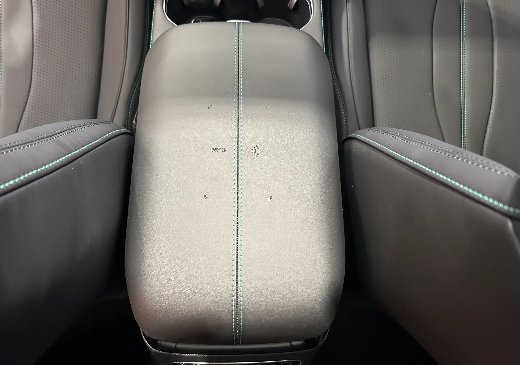 Vue rapprochée de l’accoudoir central en cuir noir avec surpiqûres vertes du BYD SEAL U hybride rechargeable.