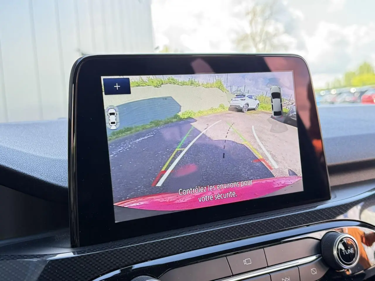 Écran tactile intérieur montrant la caméra de recul avec vue arrière du Ford Kuga rouge Lucifer.