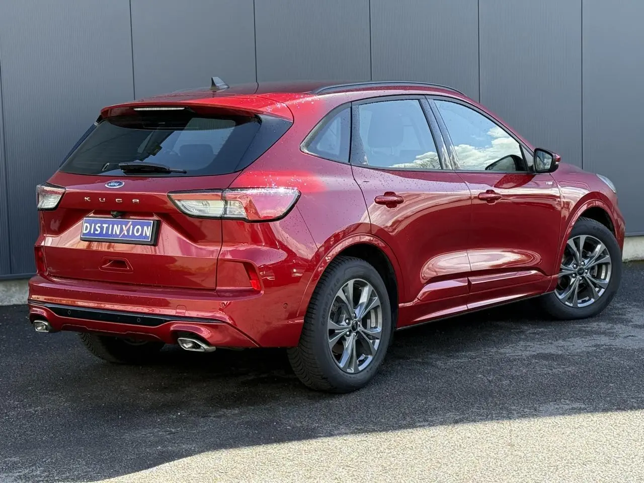 Vue 3/4 arrière droit d'un Ford Kuga rouge Lucifer avec double sortie d'échappement et jantes alliage 18 pouces.