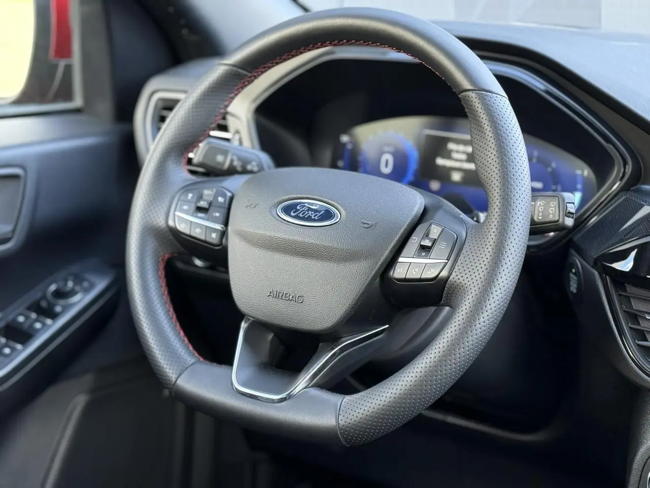 Volant perforé noir avec surpiqûres rouges et tableau de bord numérique du Ford Kuga 2.0 EcoBlue 120 BVA ST-Line.