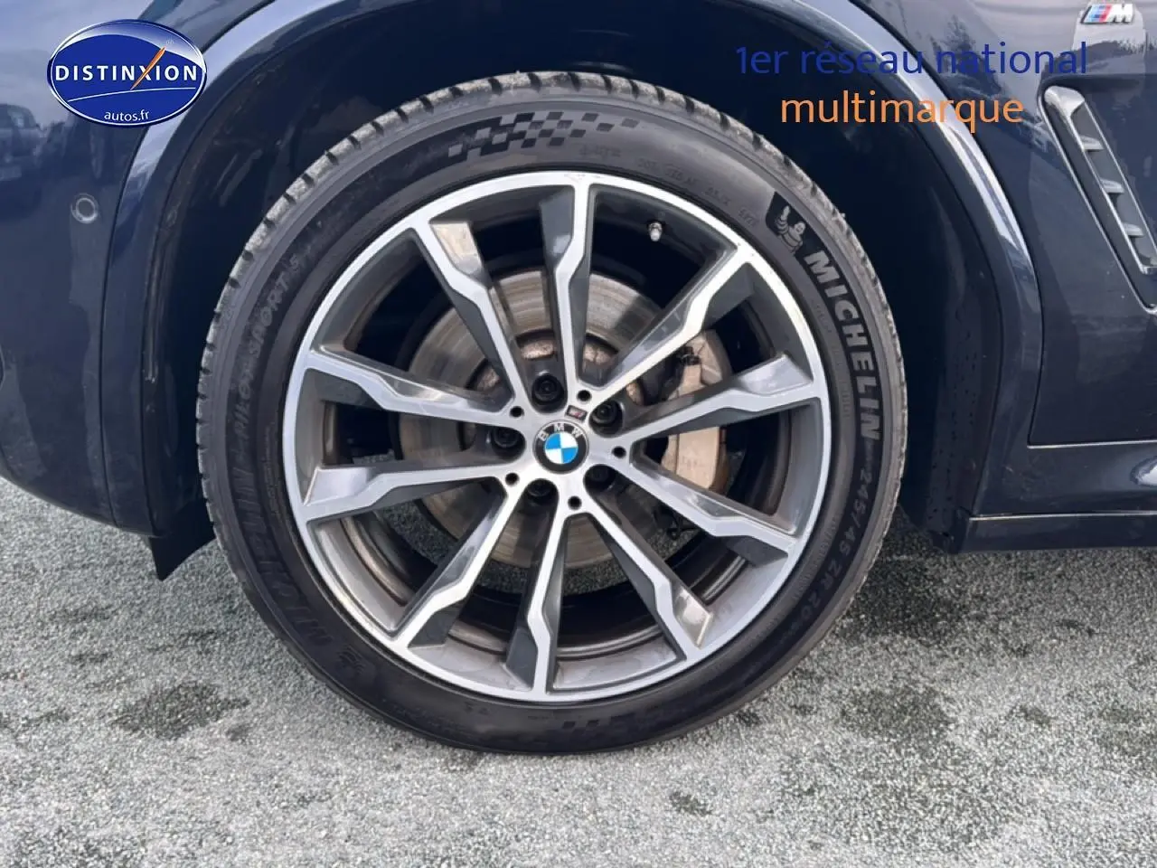 Gros plan sur la roue avant droite avec jante alu et logo BMW sur BMW X4 noir (g02) xdrive30d 2022.