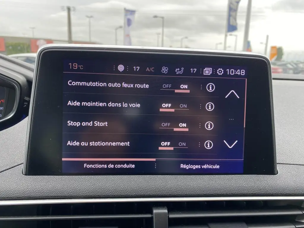 Écran tactile central du Peugeot 3008 blanc 2018 affichant les réglages d’aides à la conduite en intérieur.