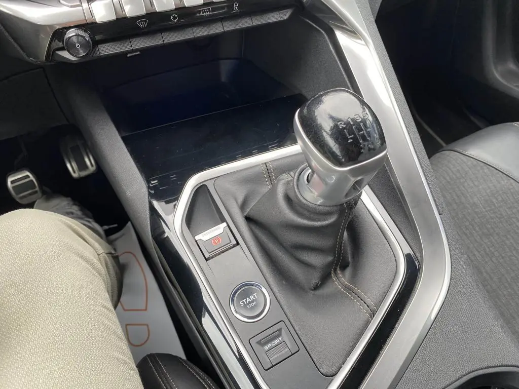 Gros plan sur la console centrale du Peugeot 3008 blanc 2018, mettant en valeur le levier de vitesse manuel et les boutons Start/Stop et Sport.