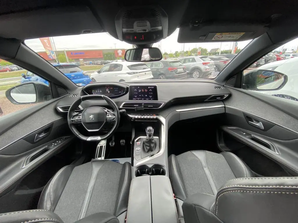 Vue intérieure avant du Peugeot 3008 blanc 2018, avec tableau de bord numérique et levier de vitesse manuel visible.