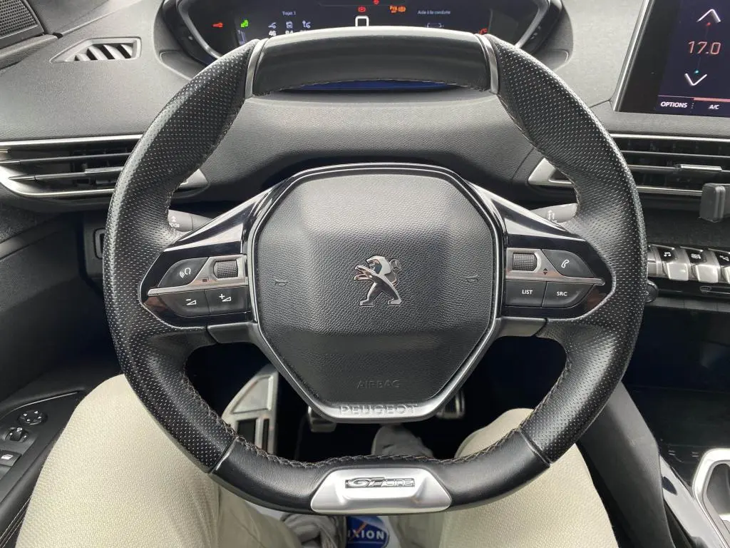 Vue rapprochée du volant cuir noir avec logo Peugeot et badge GT Line du SUV blanc Peugeot 3008 2018.