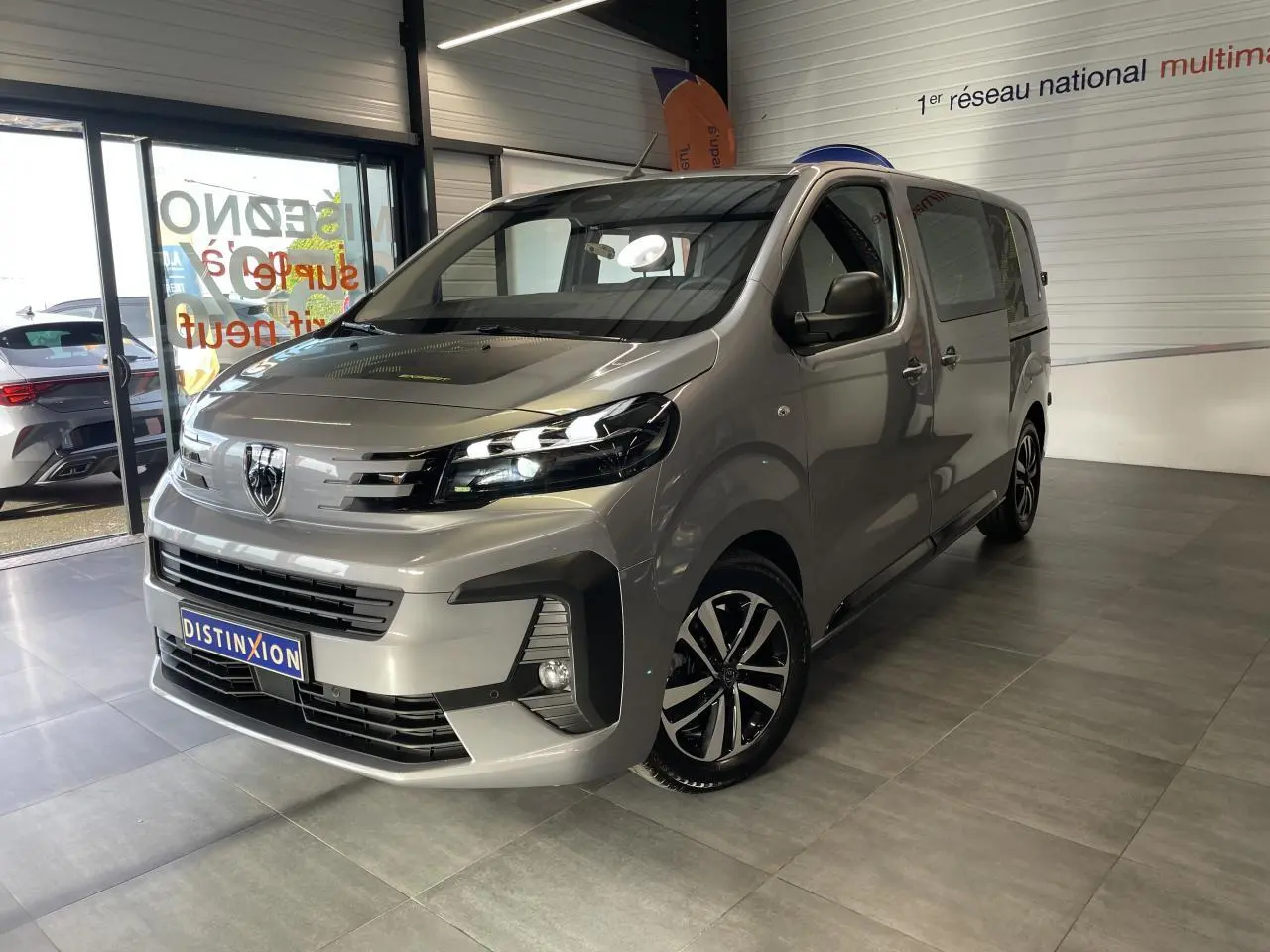 Vue 3/4 avant droit du Peugeot Expert Fourgon gris Artense avec jantes alliage et calandre distinctive showroom.