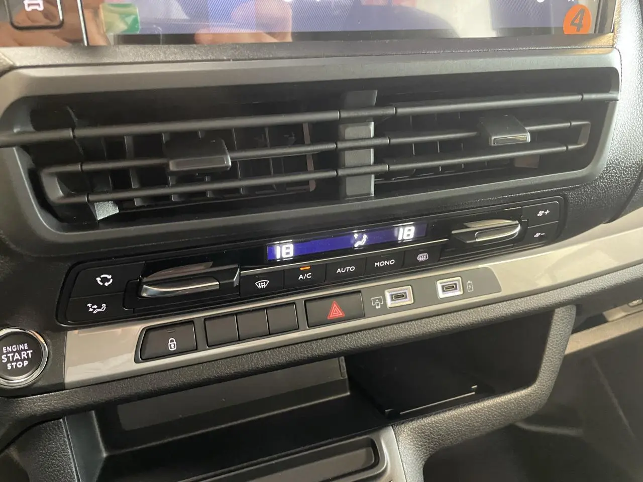 Détail de la console centrale du Peugeot Expert Fourgon gris Artense, montrant les commandes de climatisation et prises USB.