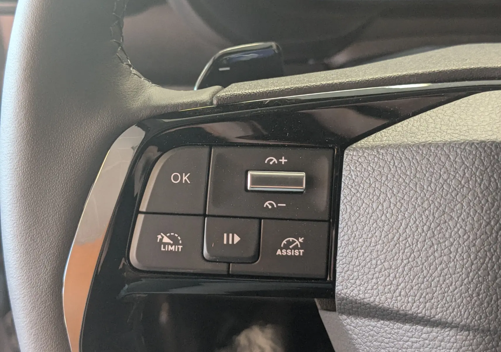 Gros plan sur les commandes de régulateur de vitesse au volant cuir noir du Citroën Berlingo 1.5 HDI 130 EAT8 gris Artense.