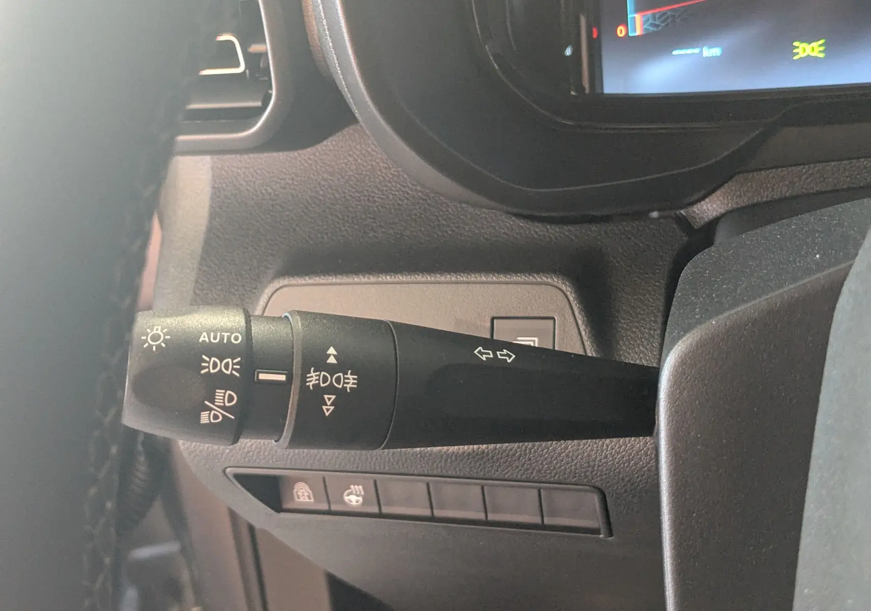 Gros plan sur la commande des feux et clignotants du tableau de bord du Citroën Berlingo gris, version 2026.