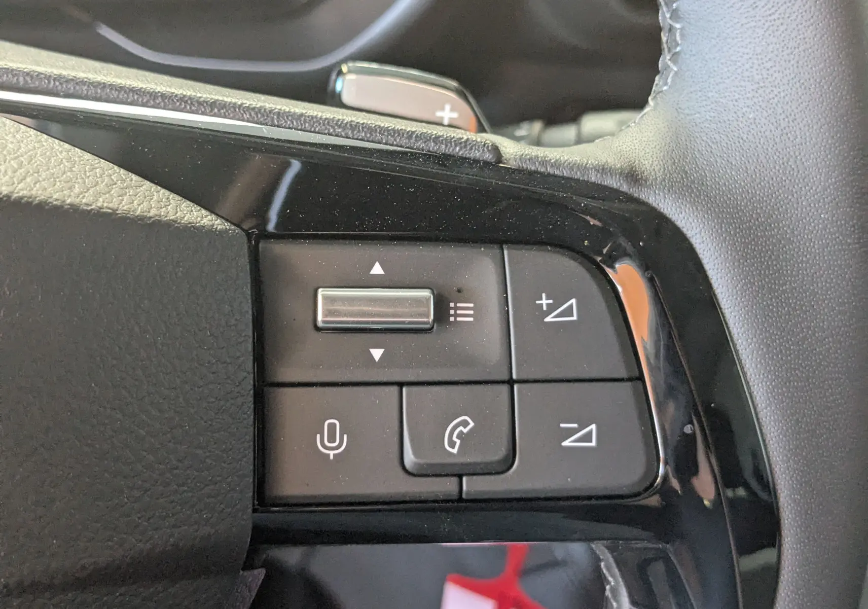 Gros plan sur les commandes du volant côté gauche du Citroën Berlingo gris Artense 2026, boutons de volume et téléphone.