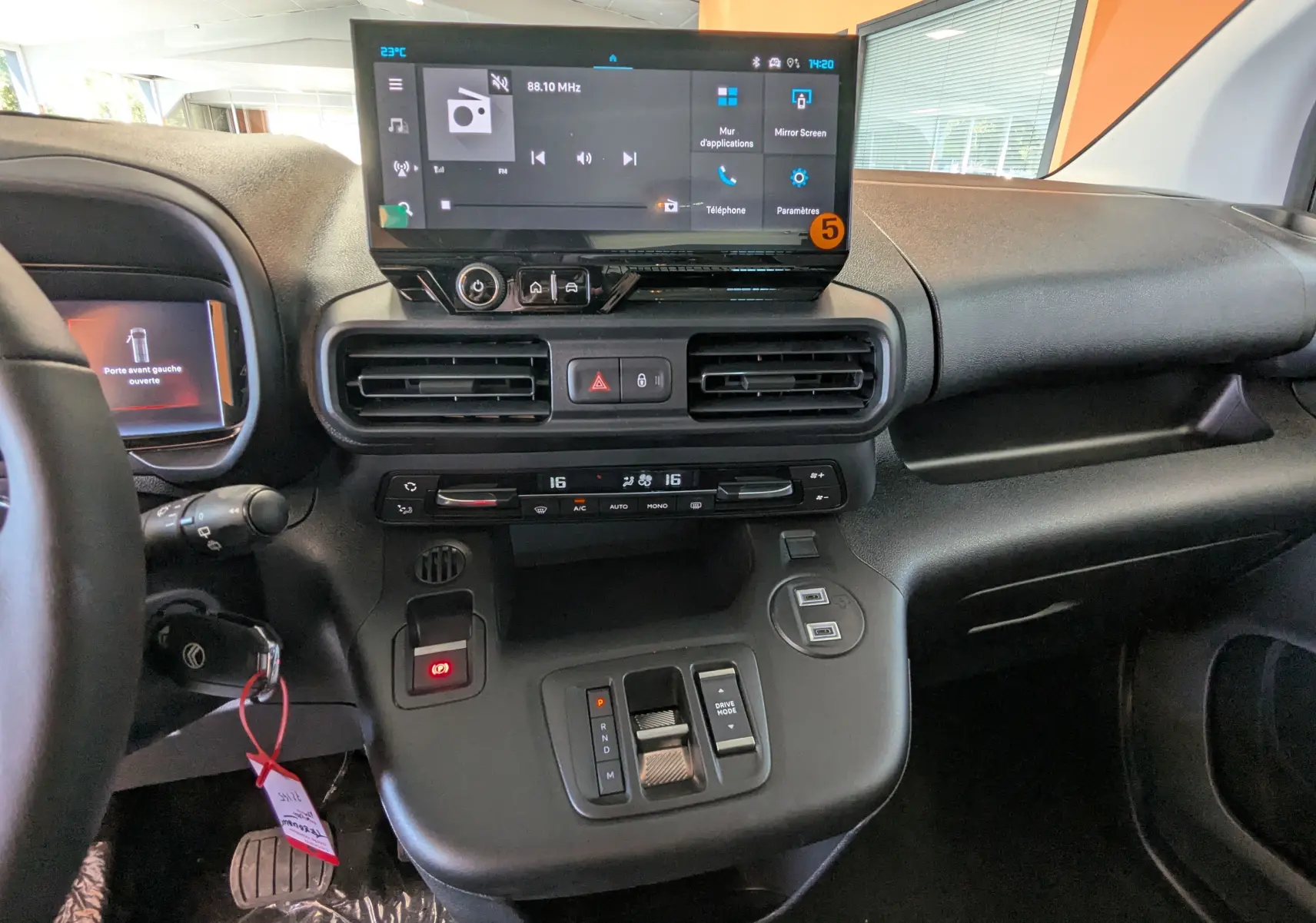 Vue intérieure du tableau de bord du Citroën Berlingo 2026 gris, avec écran tactile central et commandes de climatisation.