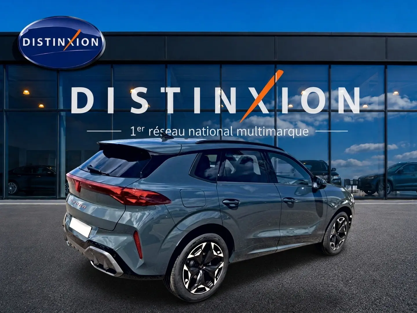 Vue 3/4 arrière droite d'une CUPRA TERRAMAR bleu fjord avec jantes 19 pouces devant une vitrine Distinxion.