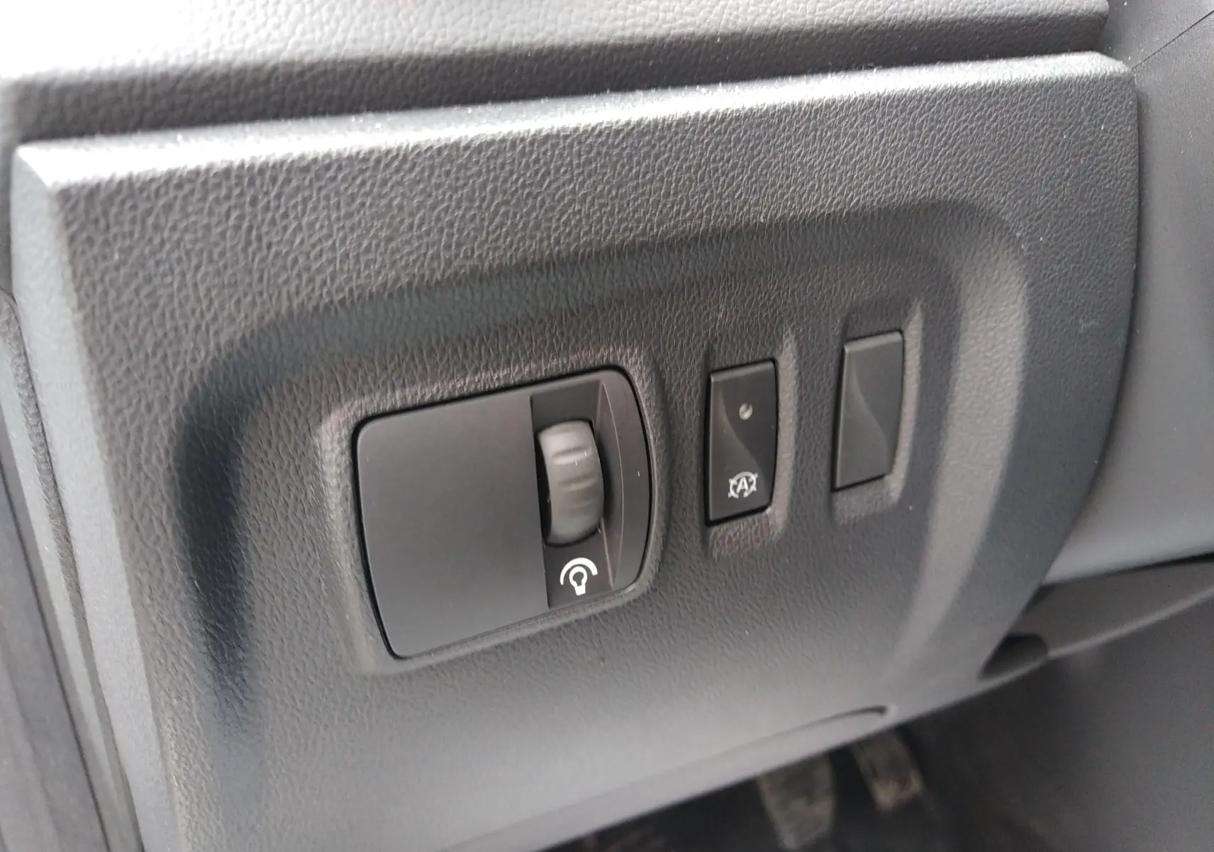 Gros plan sur les commandes de réglage du tableau de bord côté conducteur du Renault Captur blanc, version 2017.