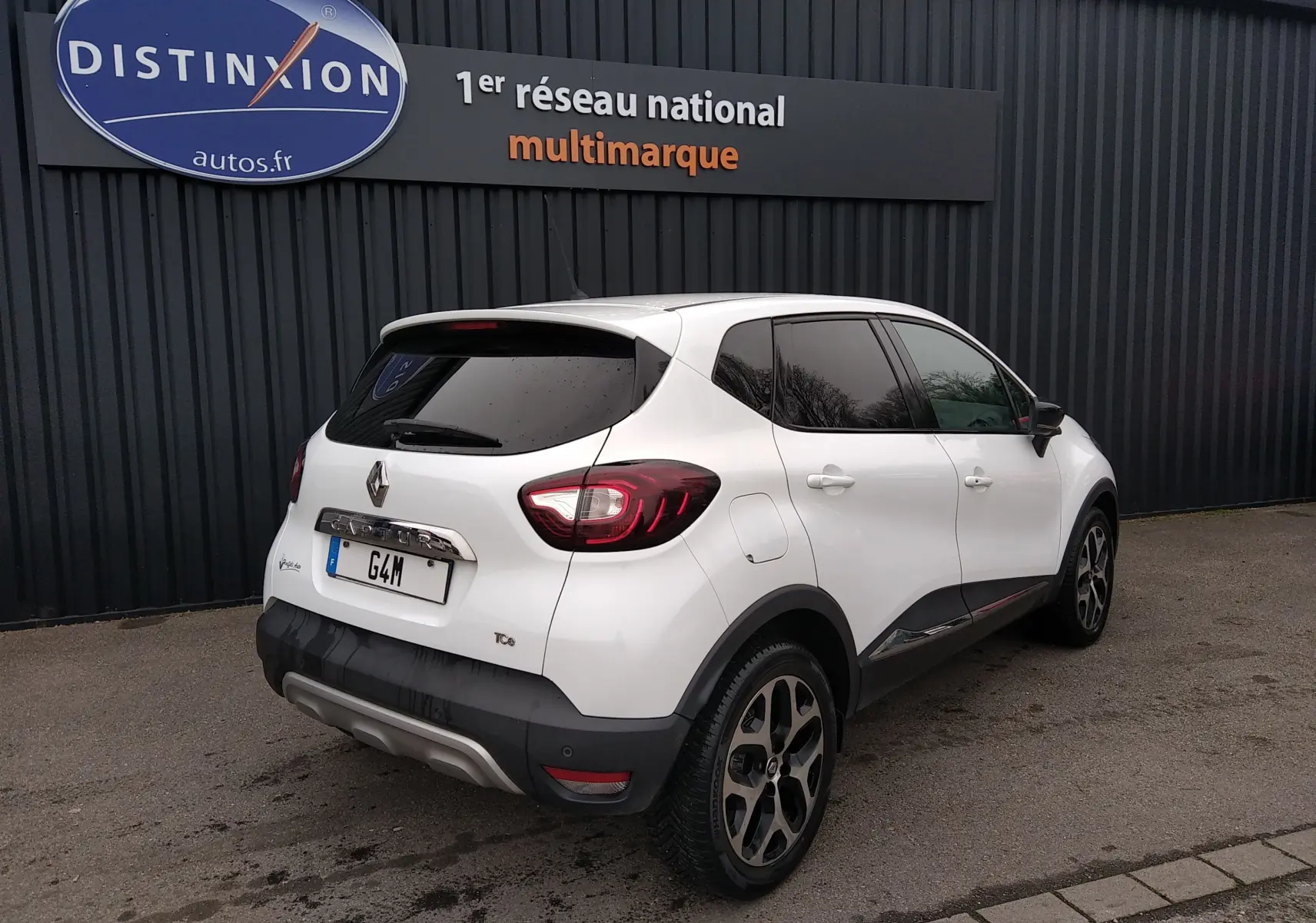 Vue 3/4 arrière droite d'un Renault Captur blanc de 2017 avec vitres teintées et jantes alliage distinctives.