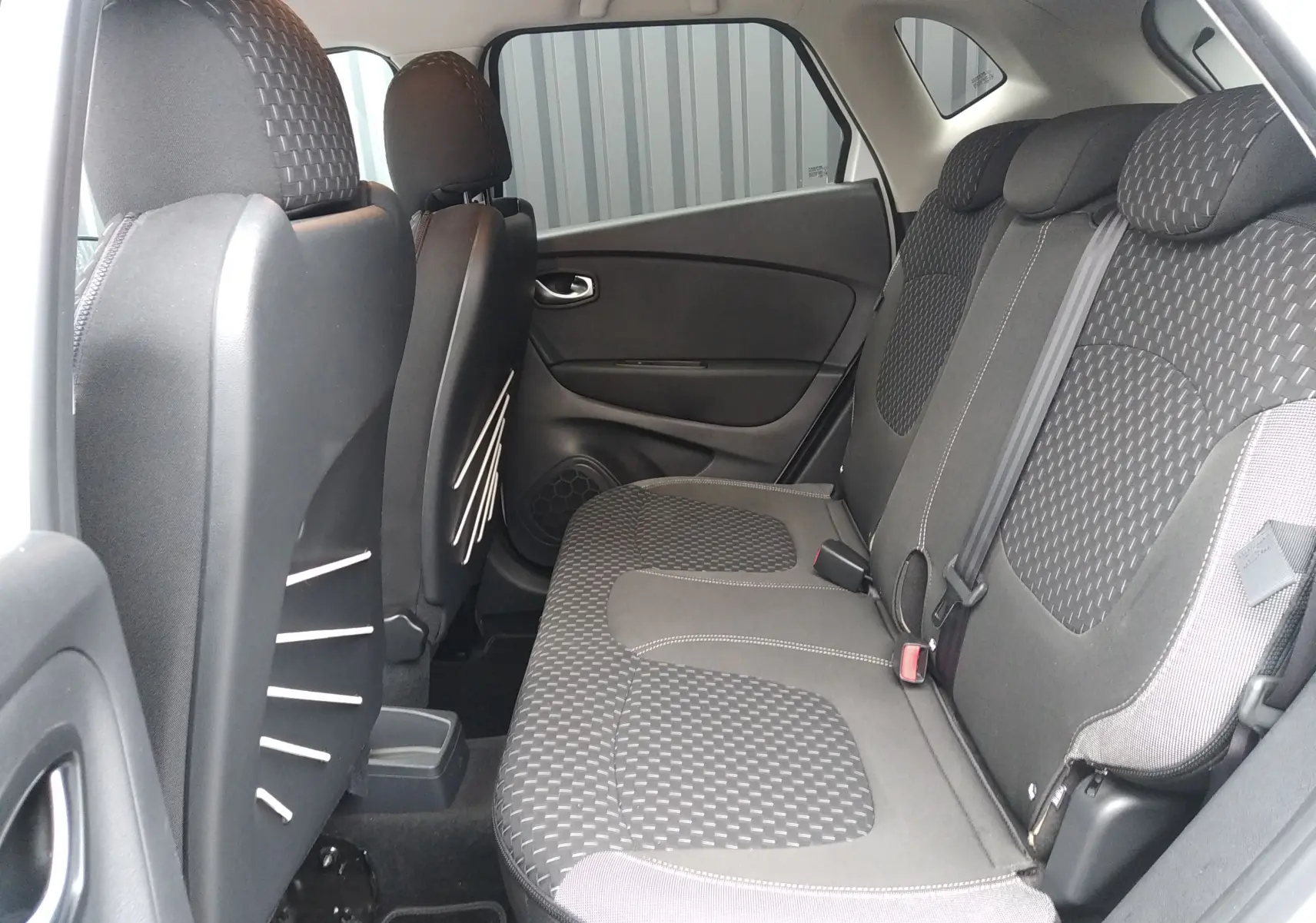 Vue intérieure côté droit des sièges arrière en tissu gris du Renault Captur blanc, version Intens 2017.