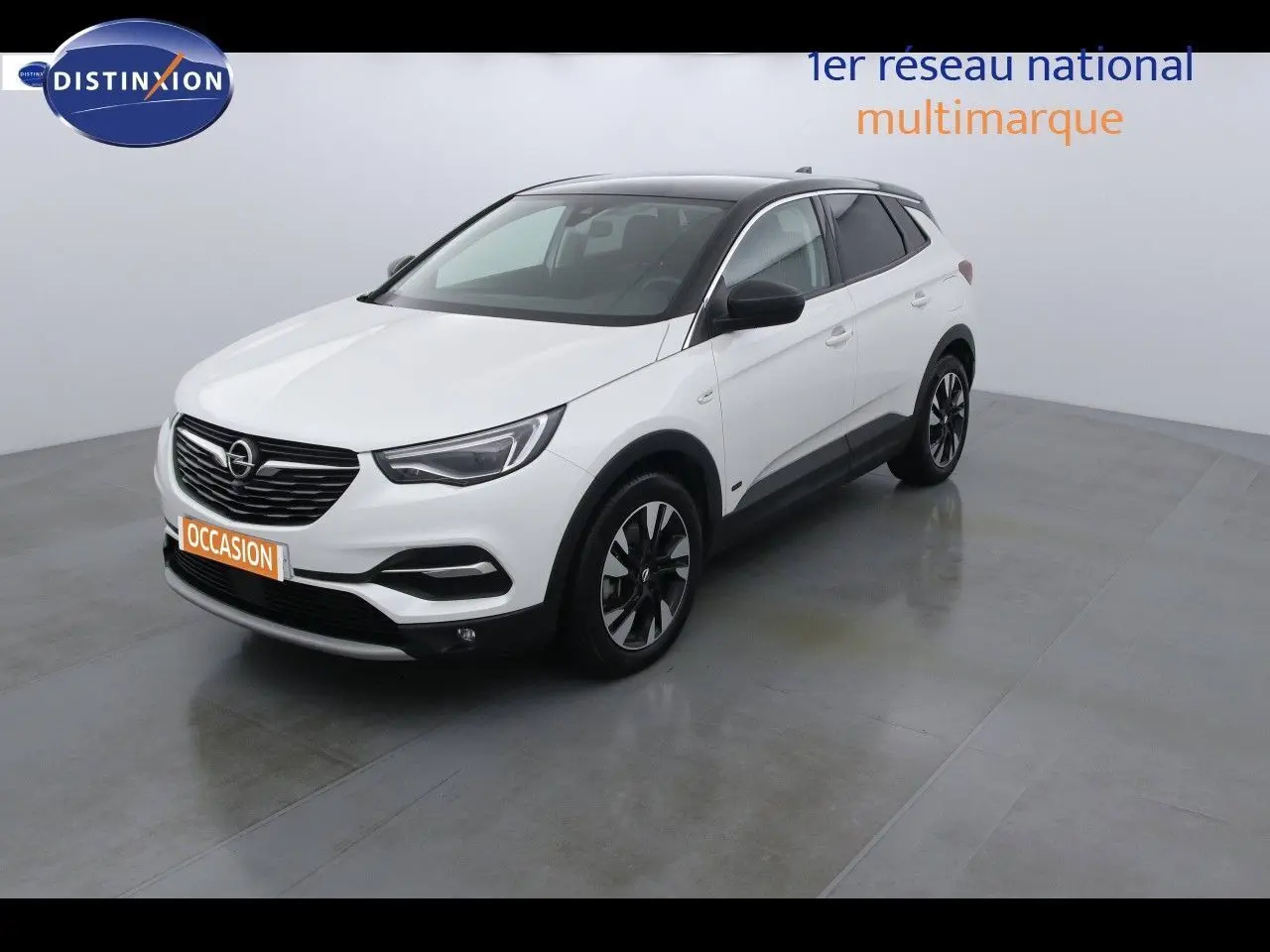 Opel Grandland X blanc nacré vu en 3/4 avant droit avec toit noir et jantes bicolores dans un studio lumineux
