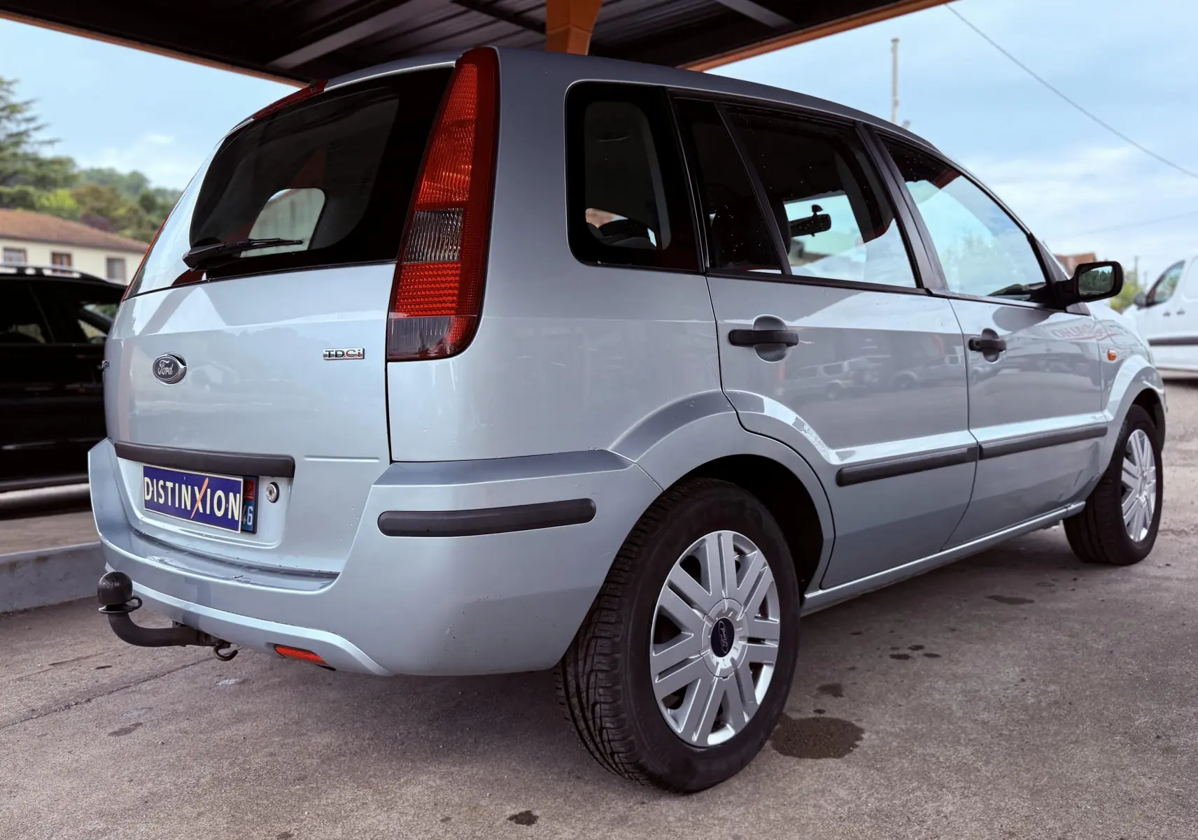Vue 3/4 arrière droite d'une Ford Fusion bleu clair de 2002 avec hayon et attelage visible.